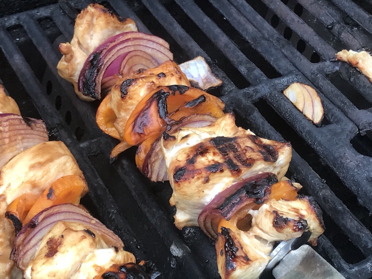 Chicken Breast with red onion and orange bell pepper on a skewer on a grill