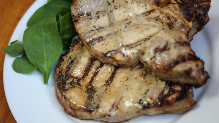 Bone in pork chops brushed with light Caesar dressing and grilled
