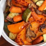 Oven roasted vegetables orange bell pepper zucchini carrots mushrooms in a white dish