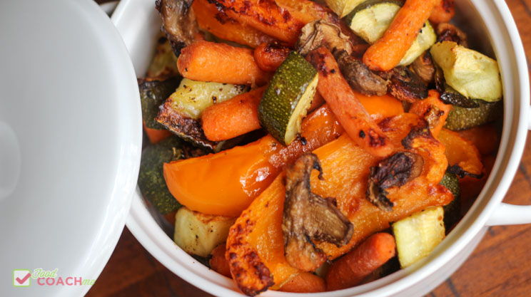 Oven roasted vegetables orange bell pepper zucchini carrots mushrooms in a white dish